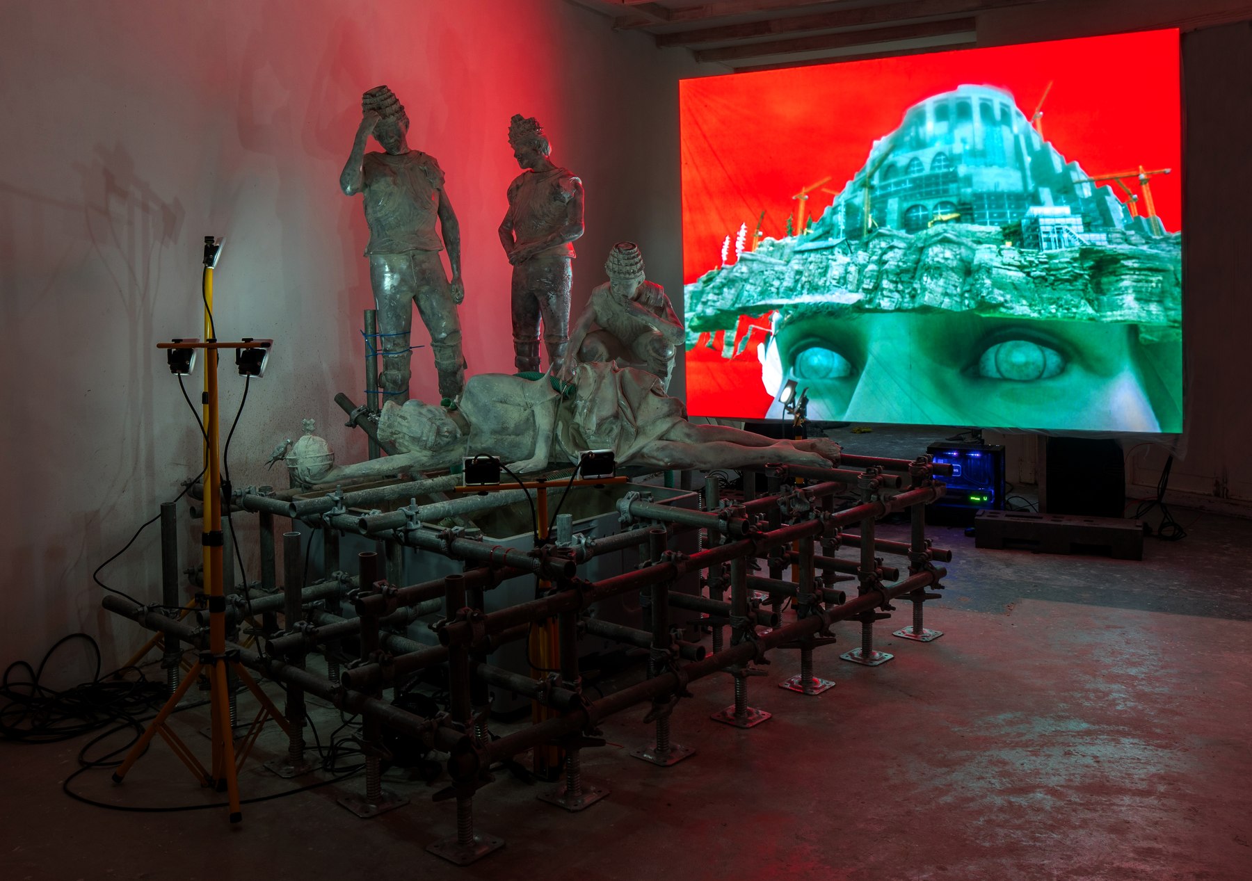 DOOMS installation, sculptures and a simulated tower in a red and turquoise-lit gallery